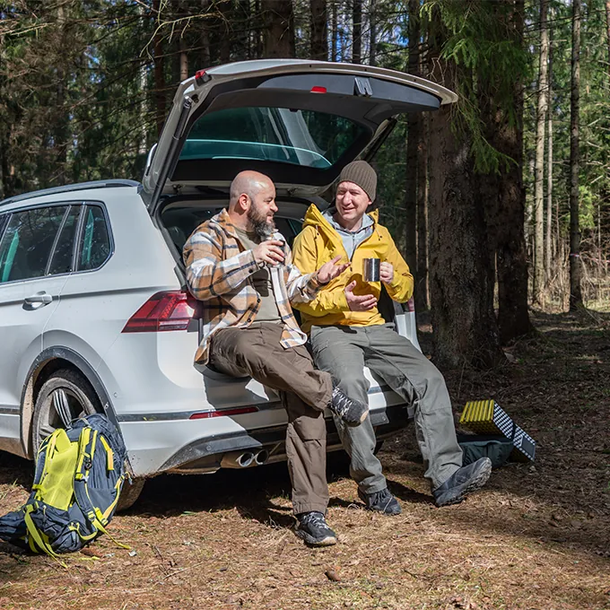 two men sitting in trunk of car