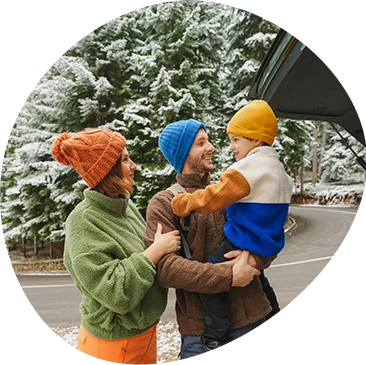 family outside vehicle in the snow